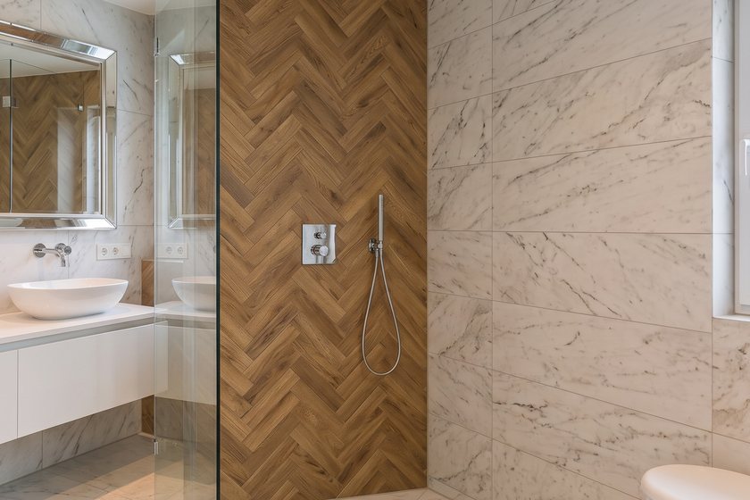 Modernes Bad mit bodengleicher Dusche, Regenbrause und Holzoptik-Fischgrätwand
